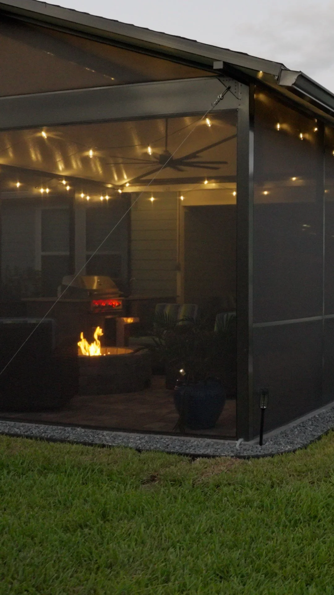Composite-roof screen enclosure with gas fire pit at dusk, Del Webb Nocatee