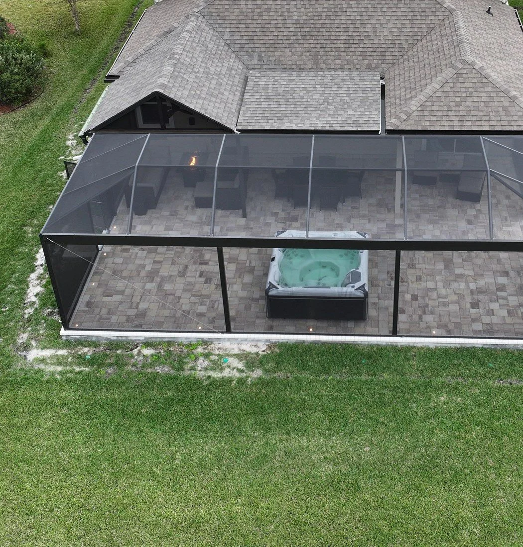 Aerial view of a screened patio with hot tub and pavers, St. Johns FL