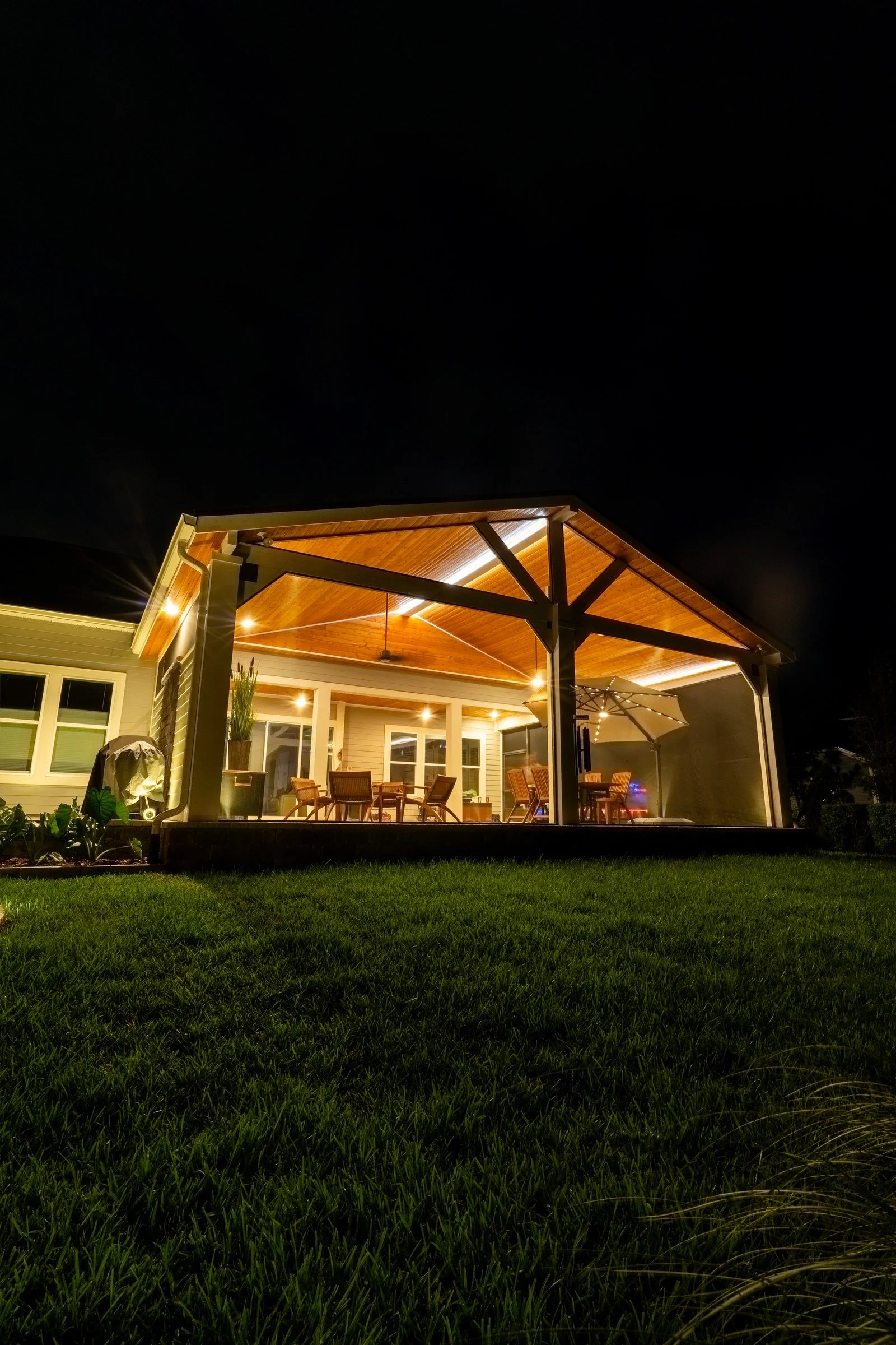 Tied-in cedar gazebo and screen enclosure lit at night in RiverTown, St. Johns FL
