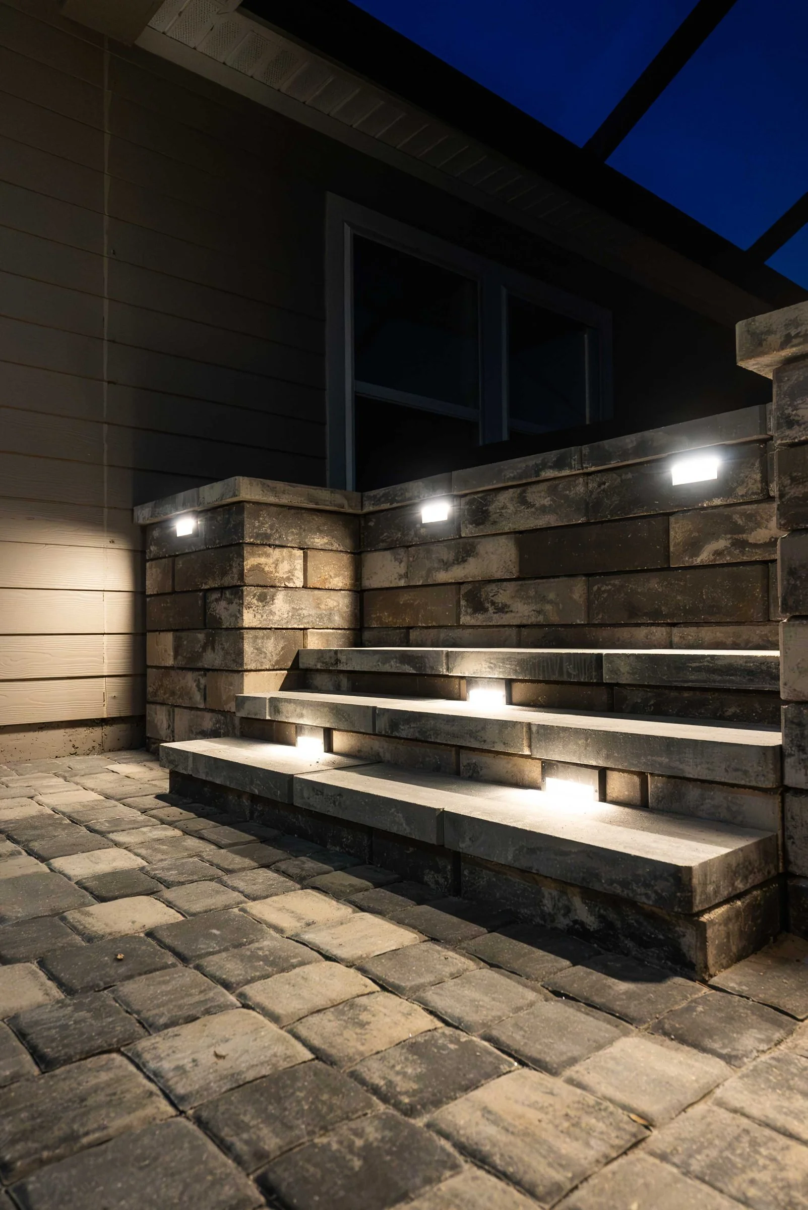 Lighted walls and steps on a paver patio at night, Stillwater