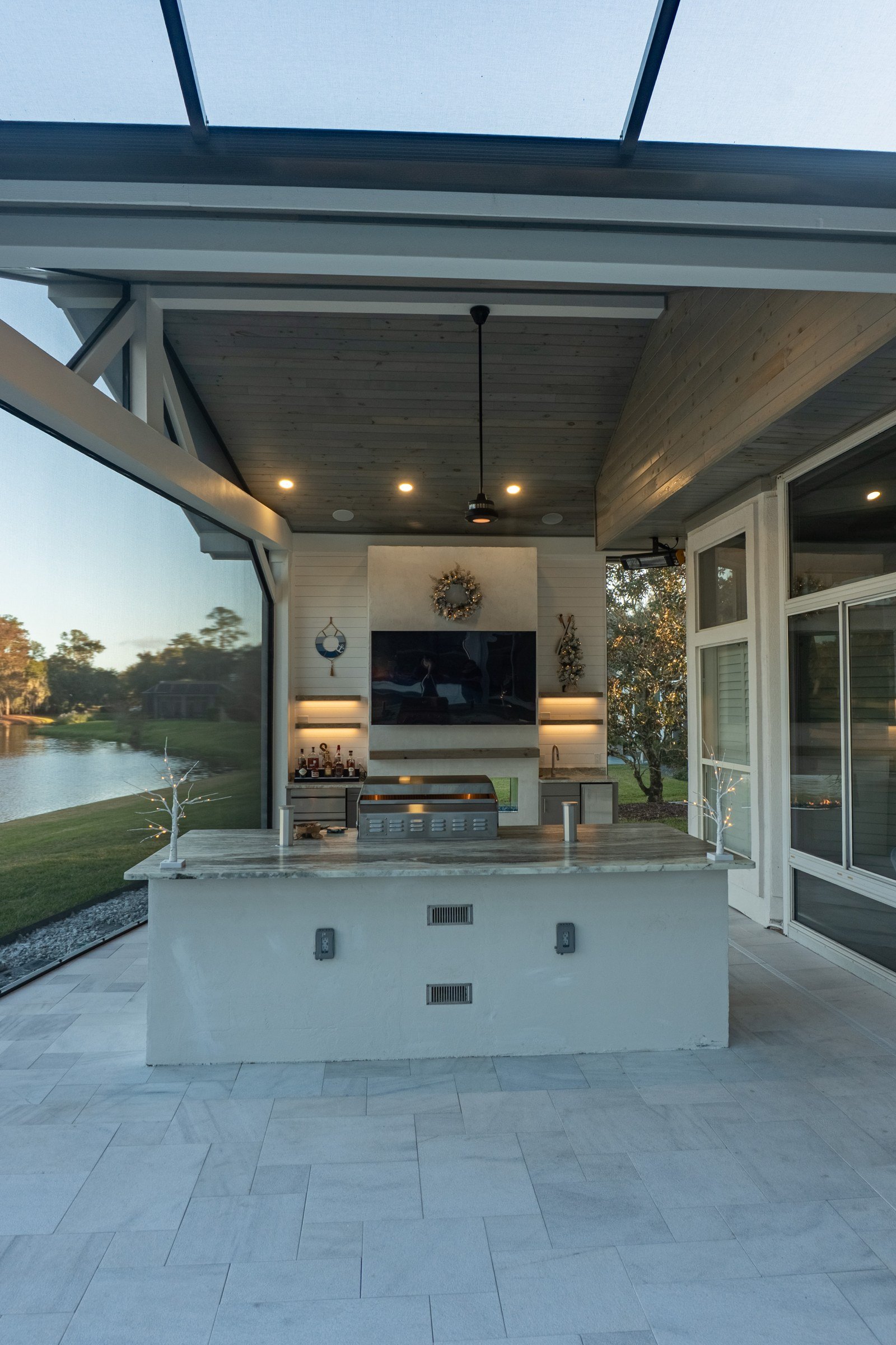 Outdoor kitchen with granite counters beside a pool under an expanded-view screen enclosure, Ponte Vedra Beach