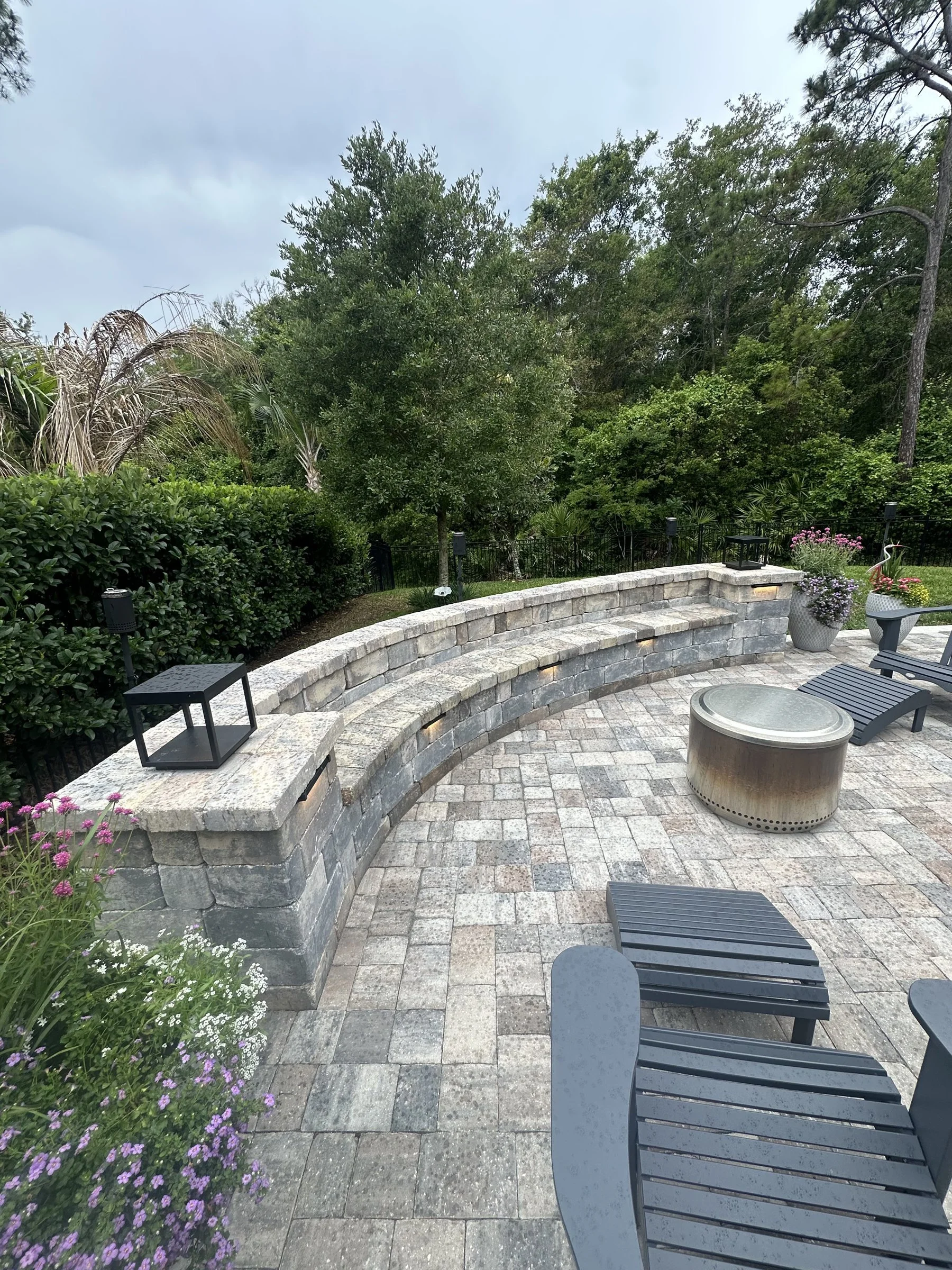 Paver patio extension with curved seating wall in Del Webb Nocatee