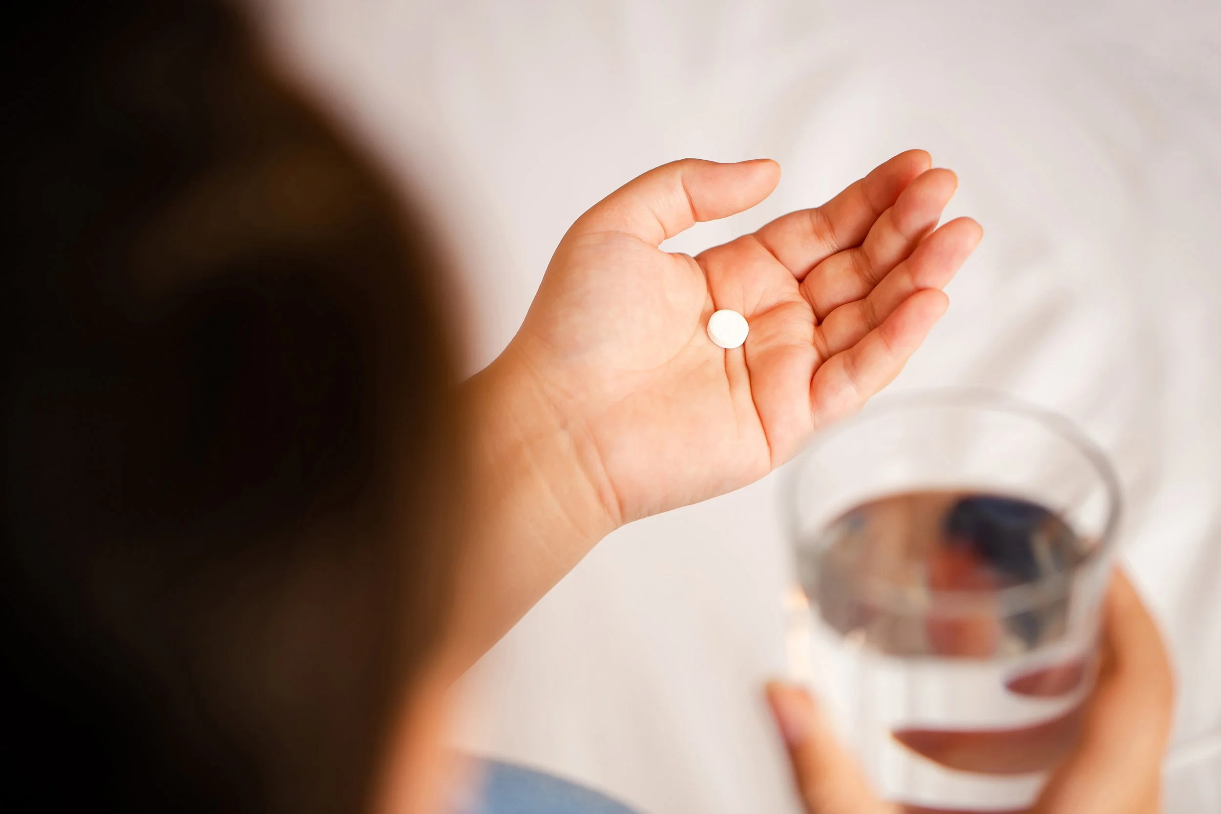 person holding a pill in their hand