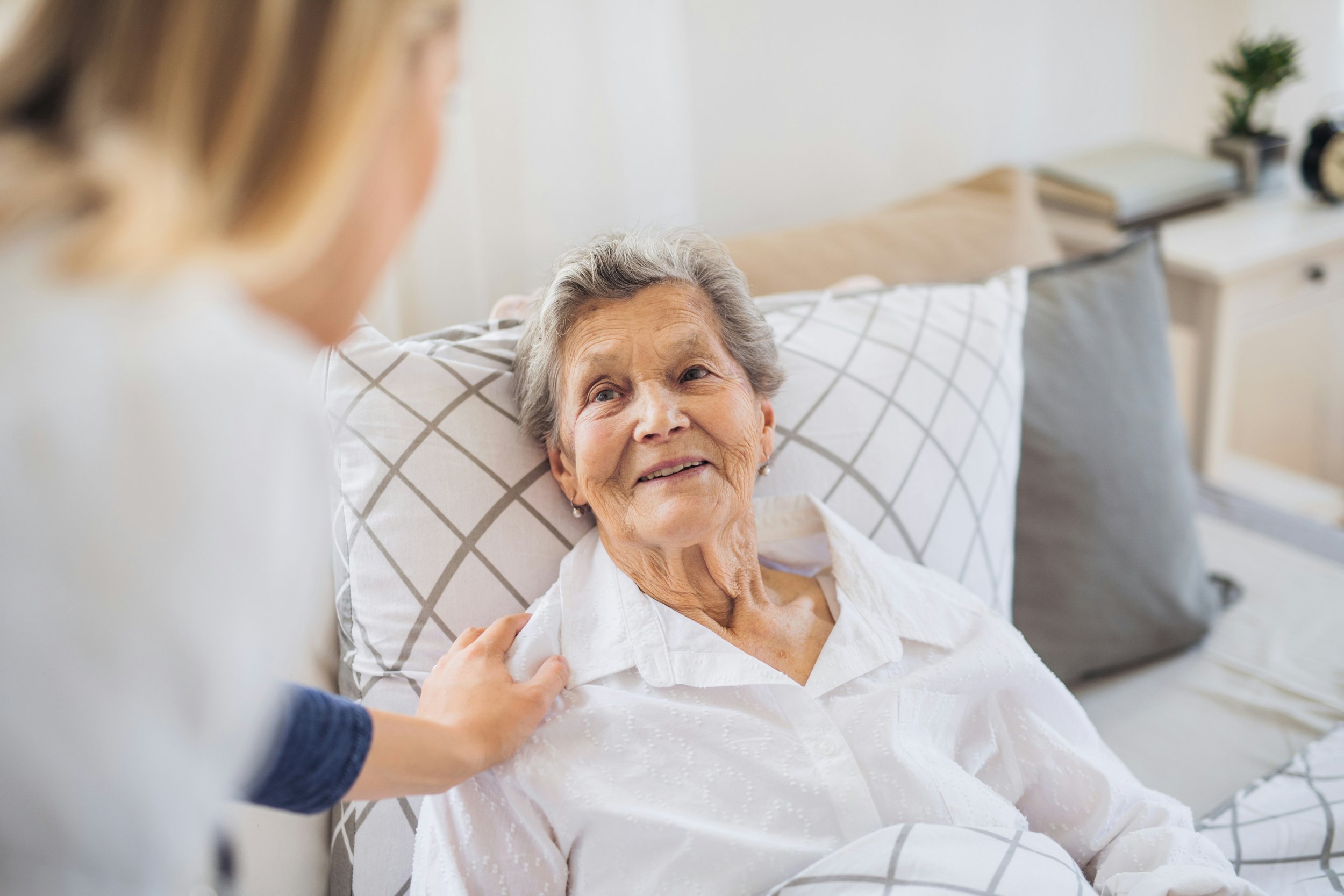 woman talking with a senior woman in her bed