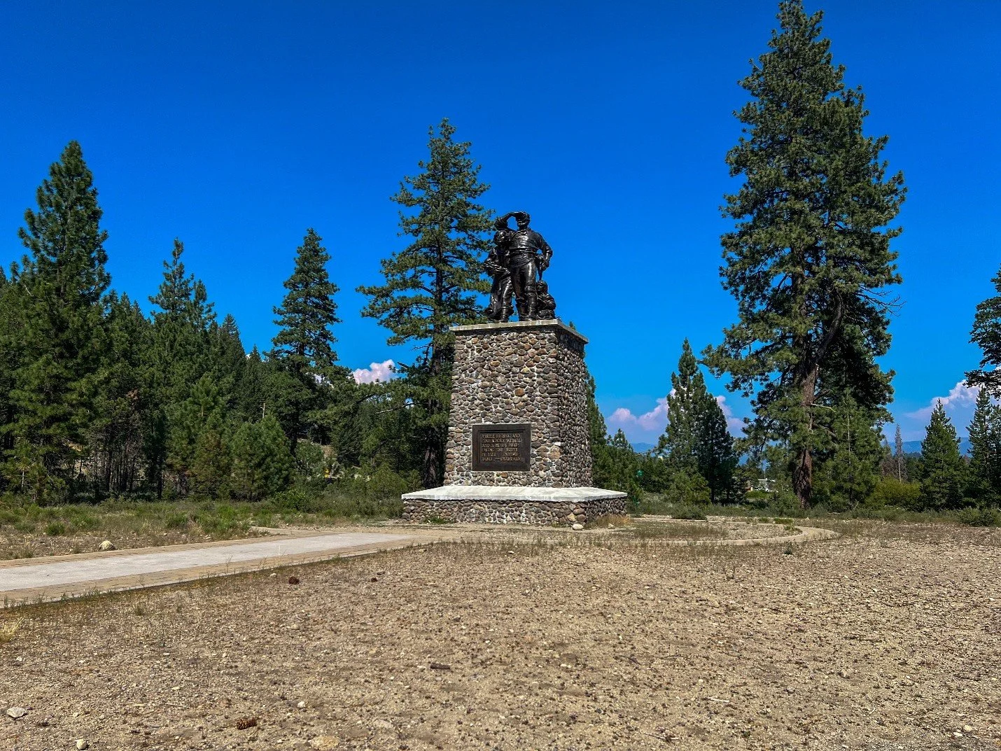 The Pioneer Monument at Donner Memorial State Park among a barren landscape, and tall confiers in the background