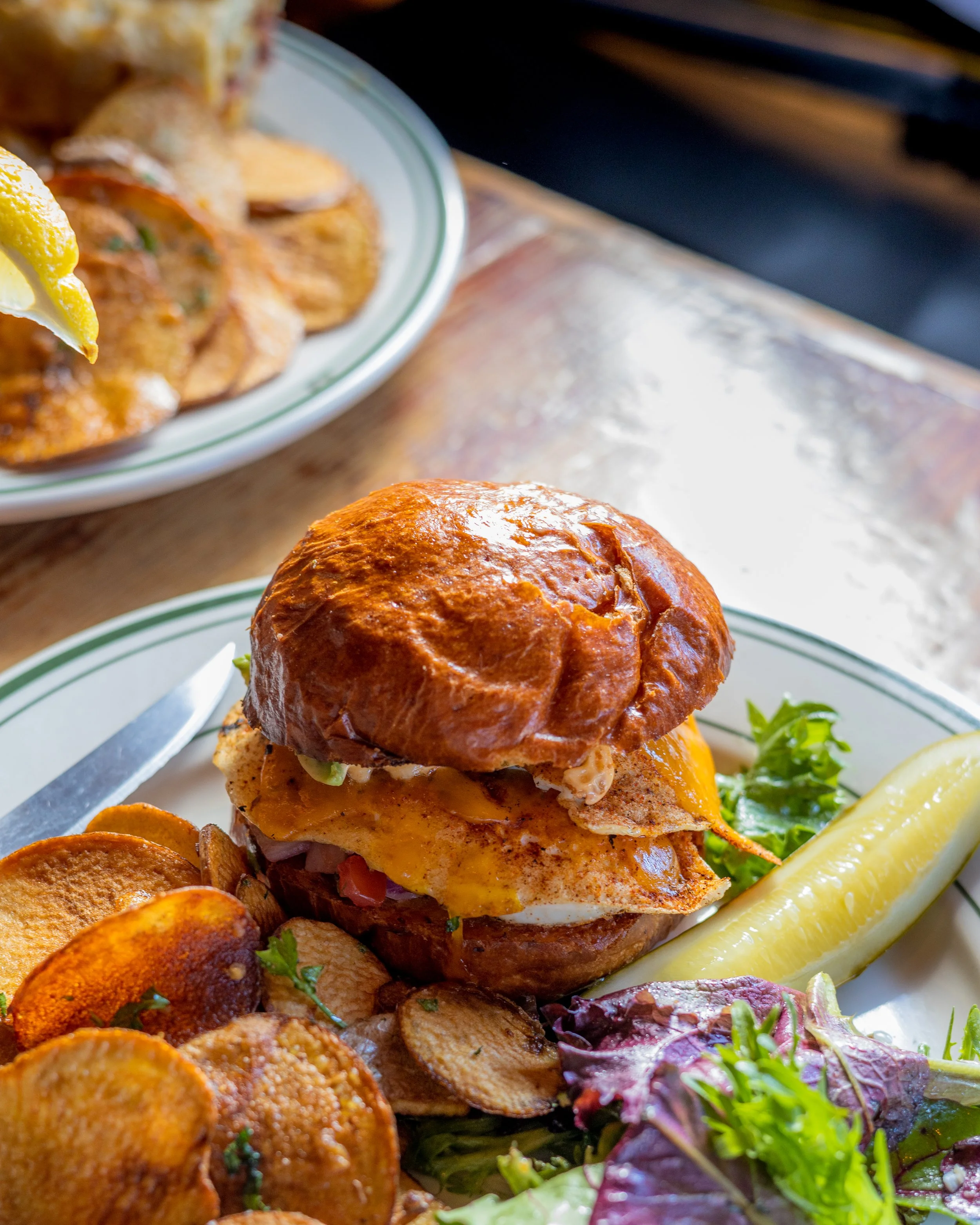A breakfast burger with a pickle, potato chips and salad from the Weary Traveler