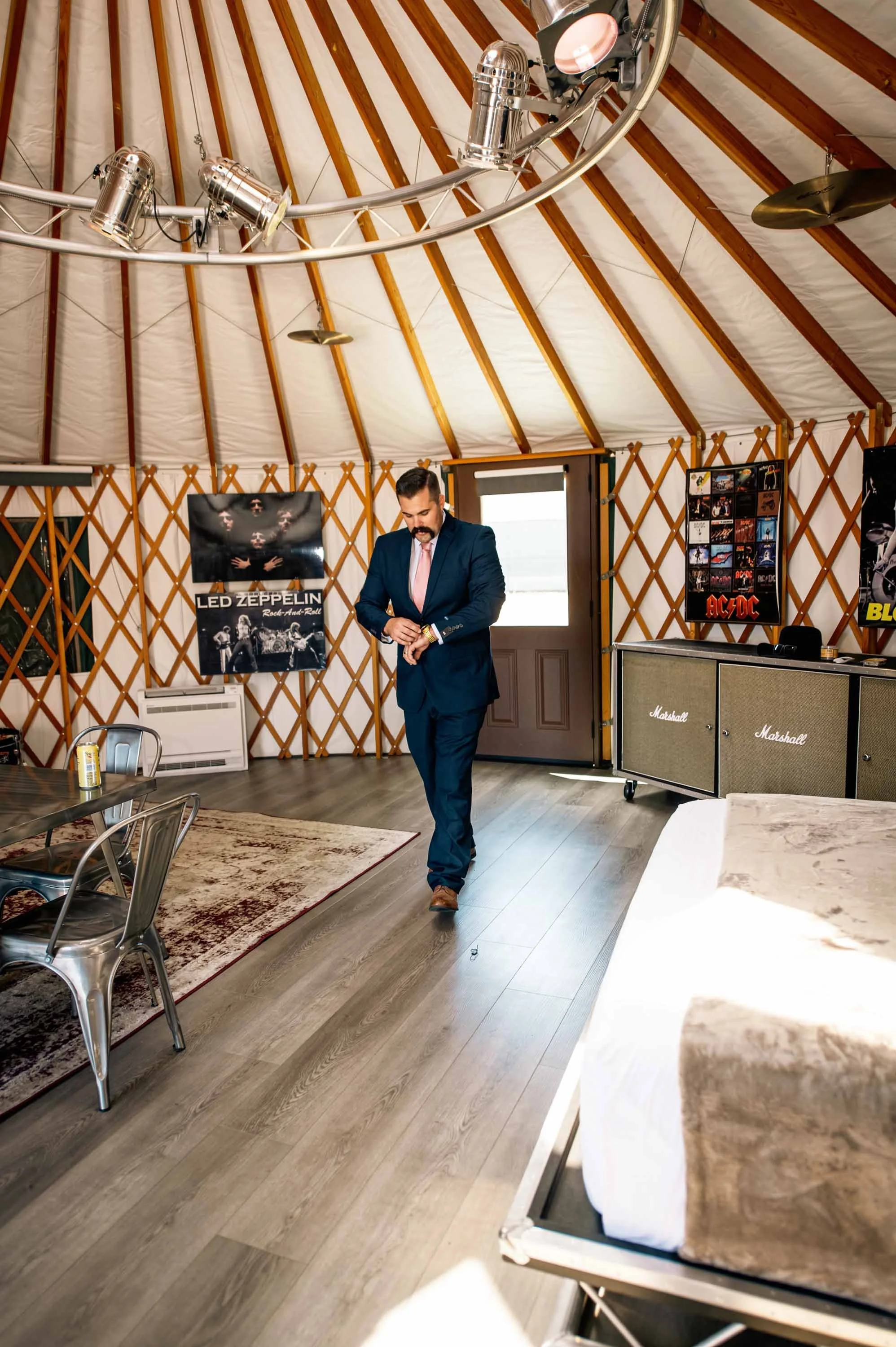 A groom getting ready inside of a yurt on his wedding day Launch Pointe in Lake Elsinore, California.