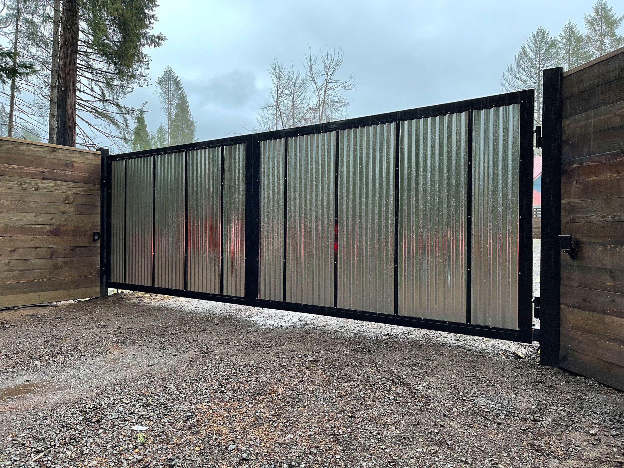 Corrugated metal gate with wooden fence in outdoor setting