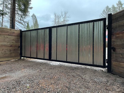 Corrugated metal gate with wooden fence in outdoor setting