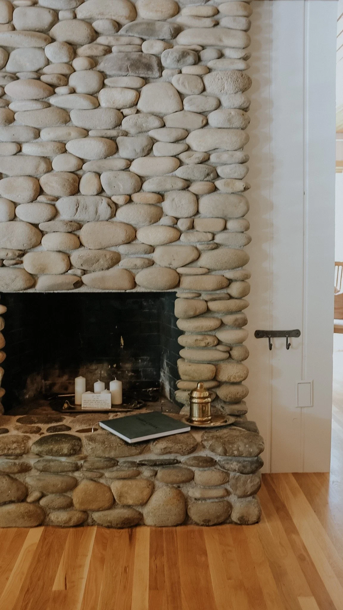 Rustic river rock fireplace inside the cozy living room at Deep Creek Farmstead.