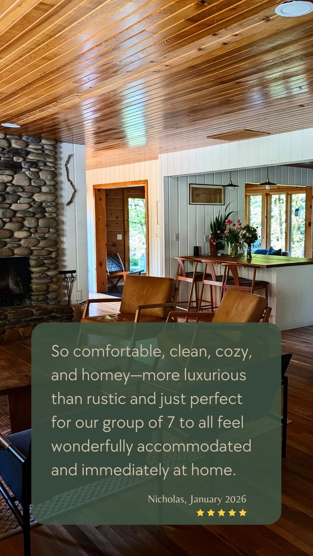A cozy, thoughtfully furnished living room with a river rock fireplace, wood ceilings, and comfortable seating at Deep Creek Farmstead near Portland.