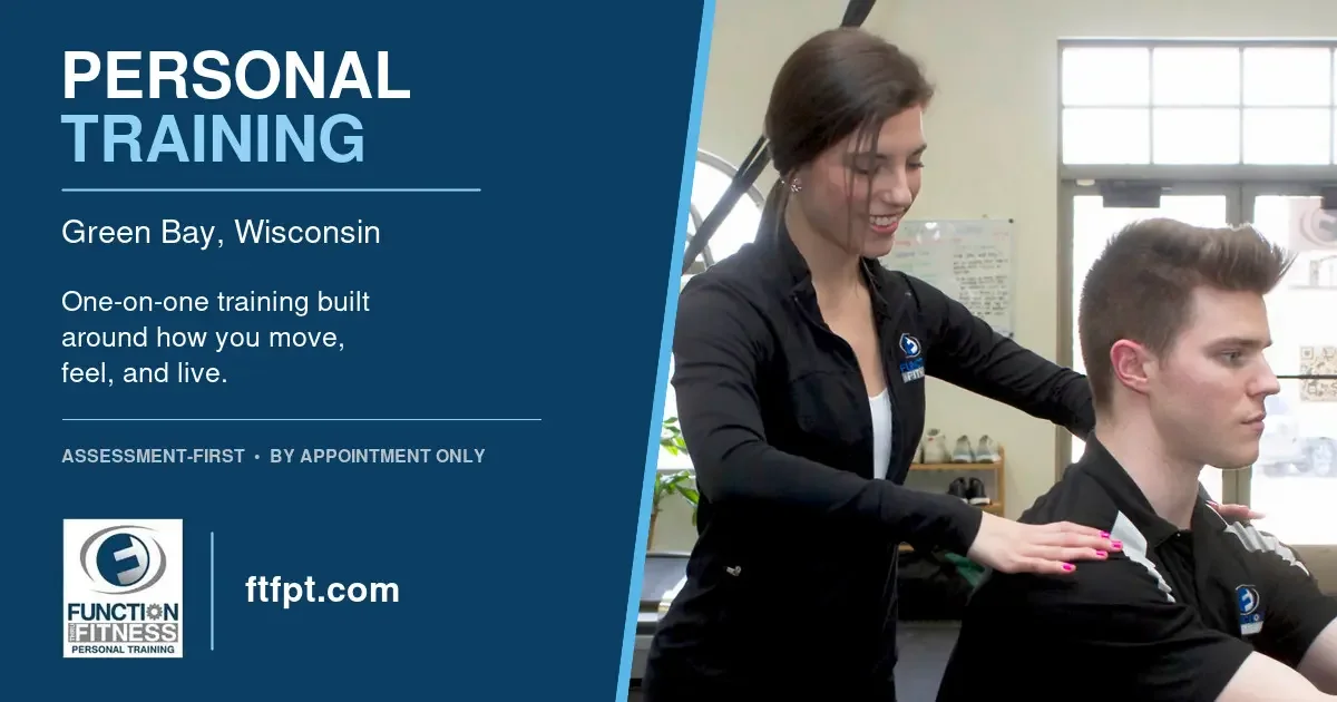 Personal trainer assesses a client’s posture and shoulder movement at Function Thru Fitness in Green Bay.