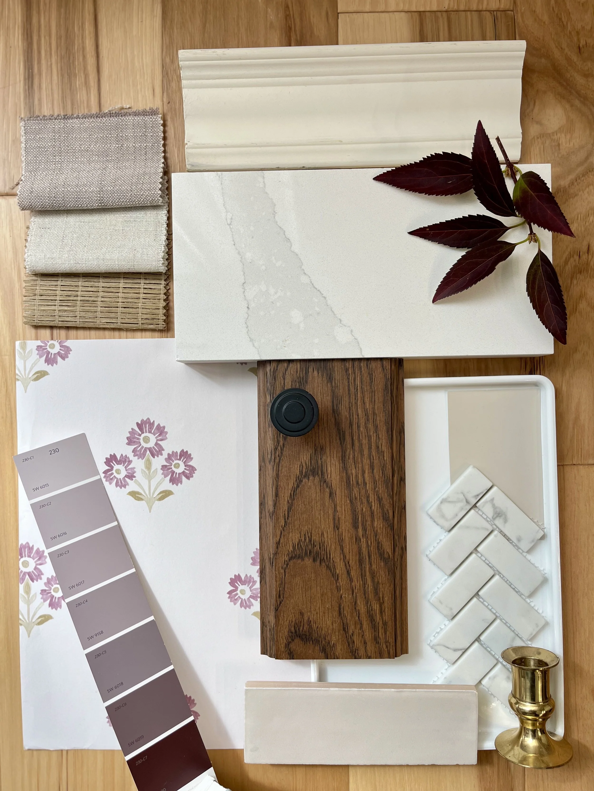 Interior design material board for a historic home featuring mauve floral wallpaper, chevron tile, marble countertop, and dark wood cabinetry.