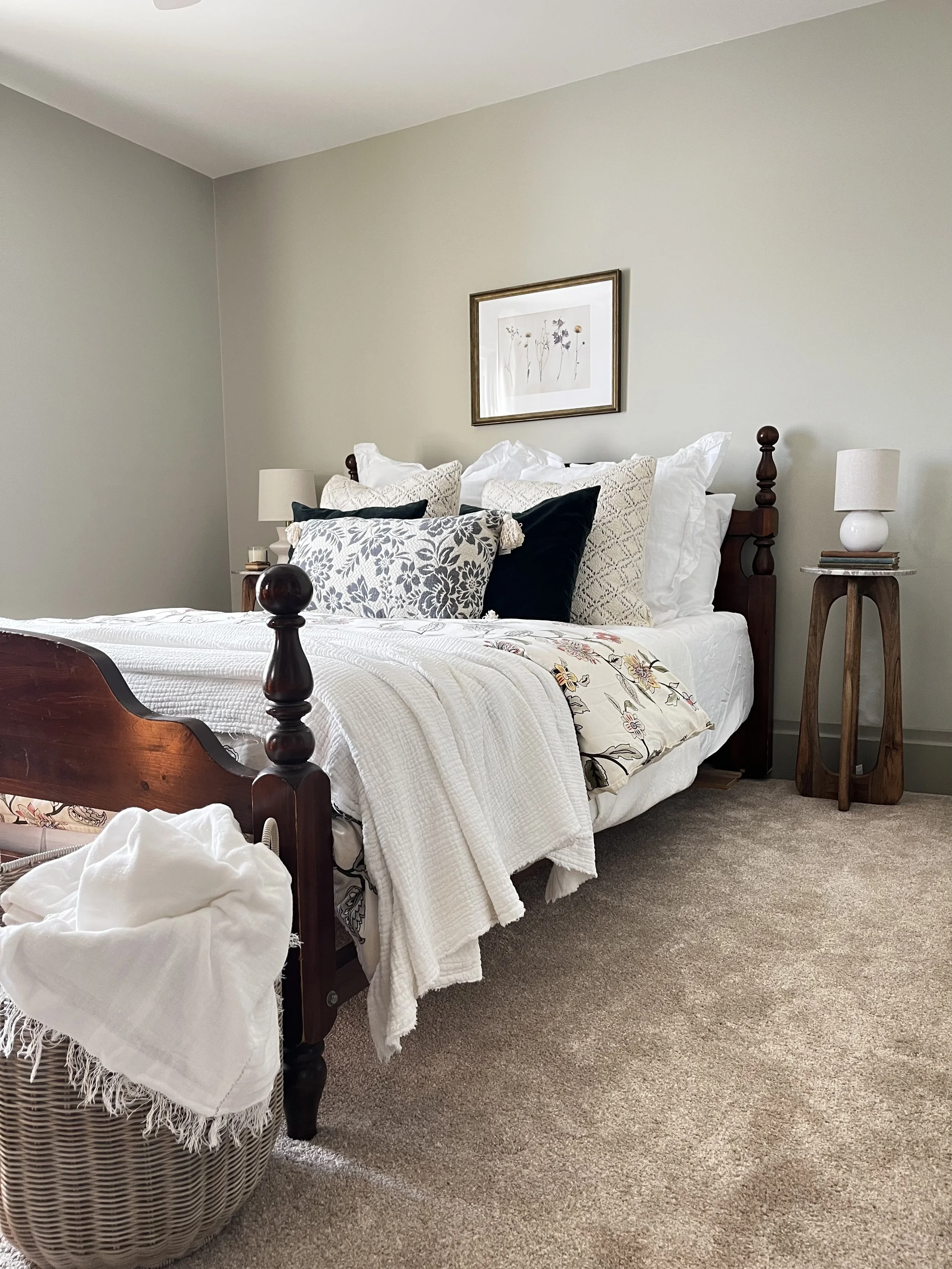 Historic bedroom interior design in Bayfield featuring soft green walls, poster bed with soft linens, and a marble top side table.