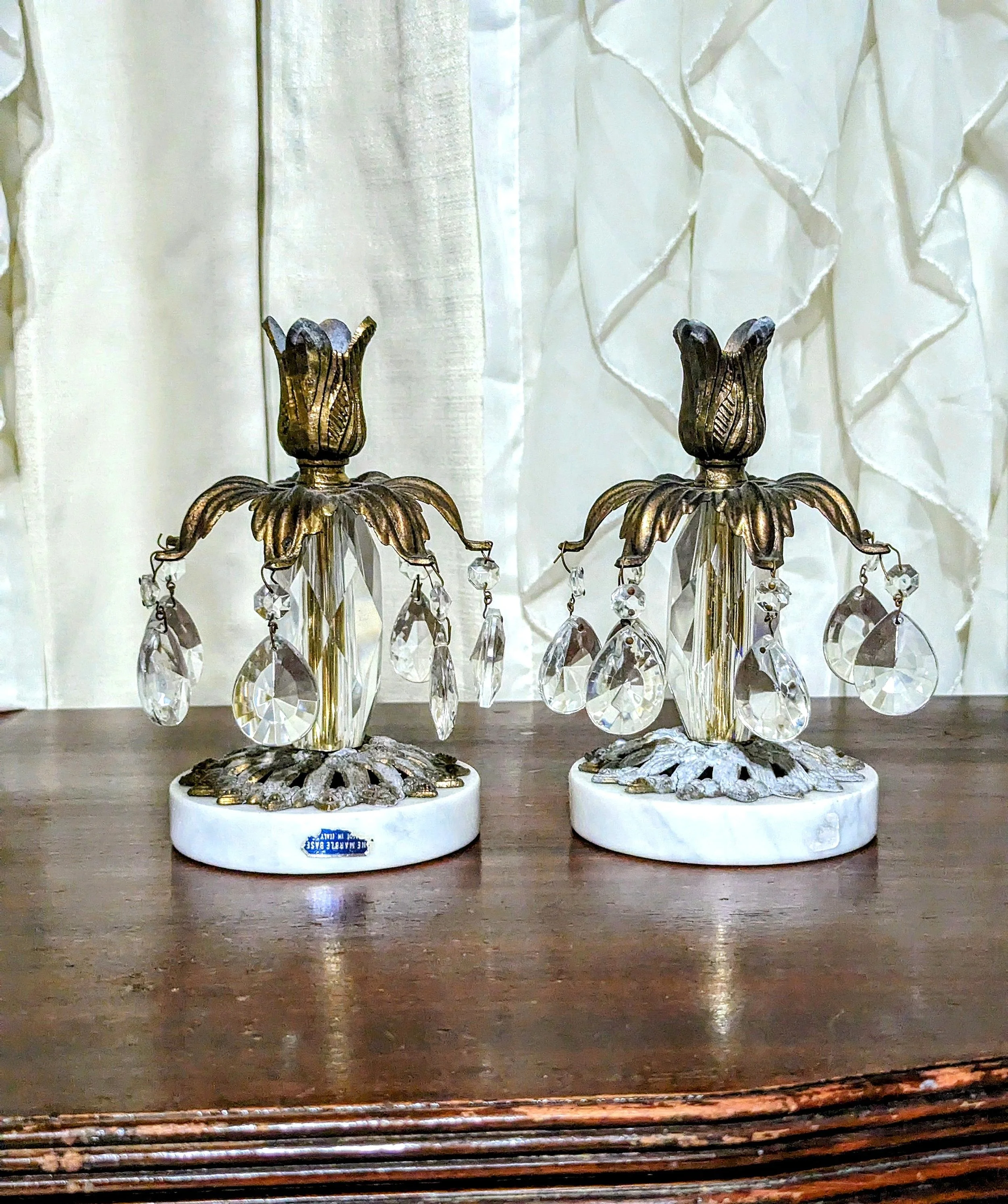 Hollywood regency style tapered candle holders. Regency flare, Floral shaped top with 7 functional extended leaves were all original crystals prisms are draped, Sturdy marble base made in Italy.