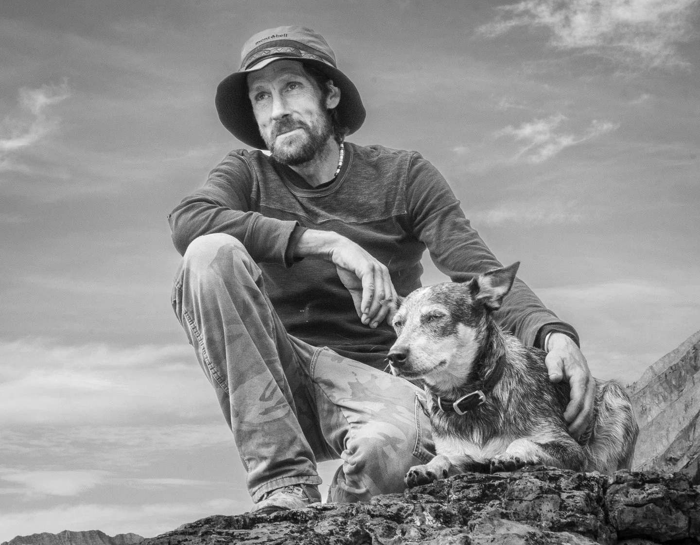 The Seeker - Warren Pearson - TVOCC (Everest Club 2023 Competition) - Best Portrait. A black-and-white photo of a man in a hat and his dog sitting together on a rocky landscape with mountains in the background.

#prpacanada #prpa #photography #portra