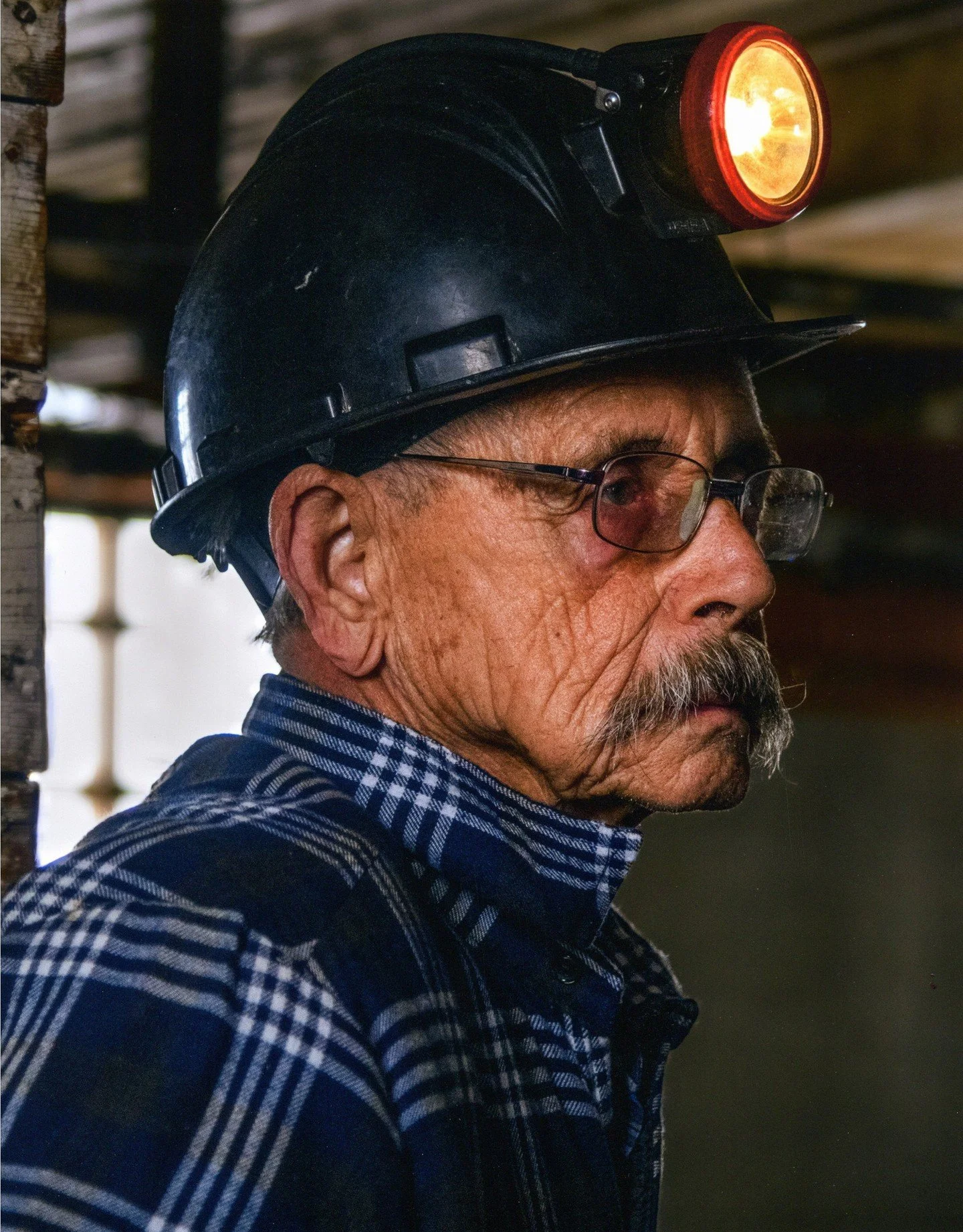 The Miner - Marlene Andrew - IWPA / Gerry Fish Club 2024 Competition - Best Portrait.

An older man with glasses and a mustache wearing a black hard hat with a lit headlamp in an industrial setting.

#prpacanada #photography #portrait #competition