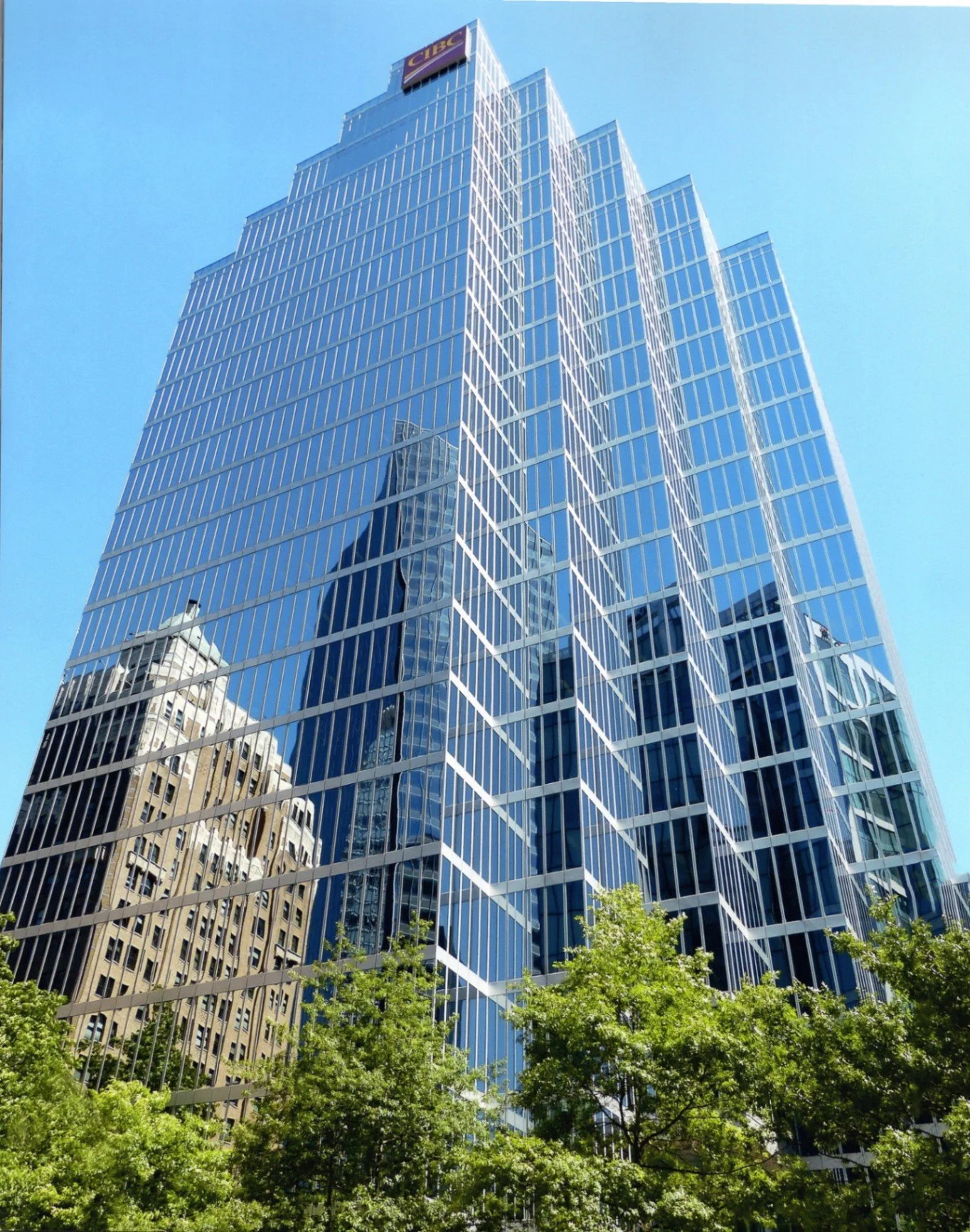 Vancouver Skyline - Sheila Smith - TVOCC / Gerry Fish Club 2024 Competition - Best of Show. This image captures a tall, modern skyscraper with a glass fa&ccedil;ade reflecting the blue sky and older buildings, featuring the CIBC logo. 

#prpacanada #