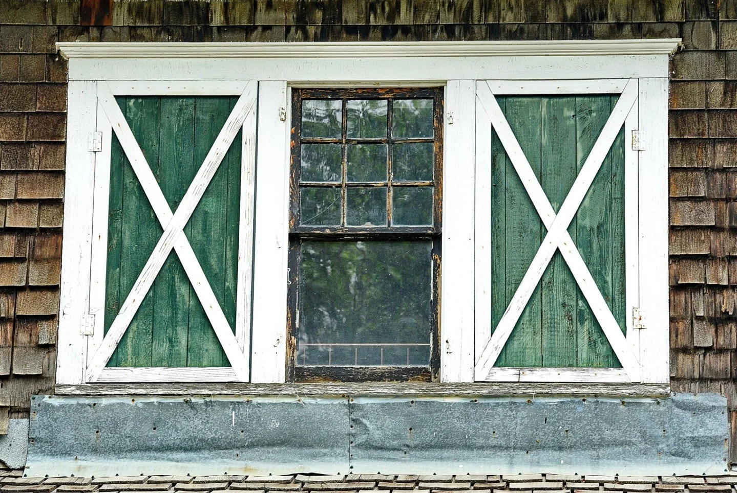 Shutters&amp;Window - Mary Ann Dudragne - IWPA / Outing - Digital Image 2024 Competition - 3rd Place.

A rustic window with green wooden shutters and an 'X' design on a shingled wall.

#prpa #photography #architecture #prairies
