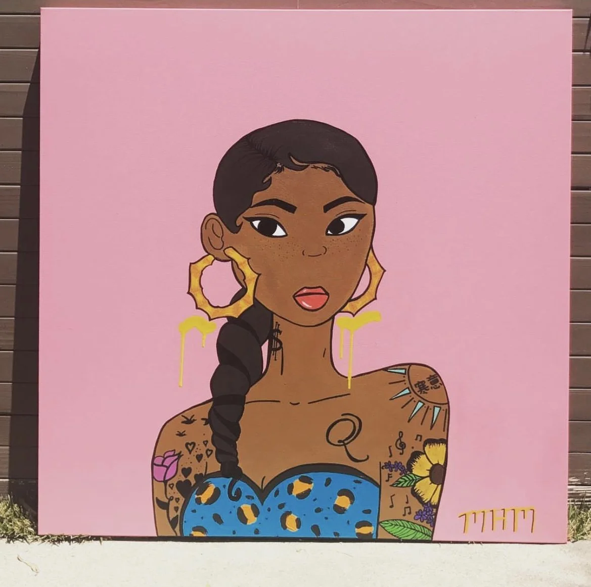 Cartoon portrait of a woman with short dark hair, large gold hoop earrings, and tattoos on her shoulders and chest, wearing a blue top with yellow leopard spots, against a pink background.