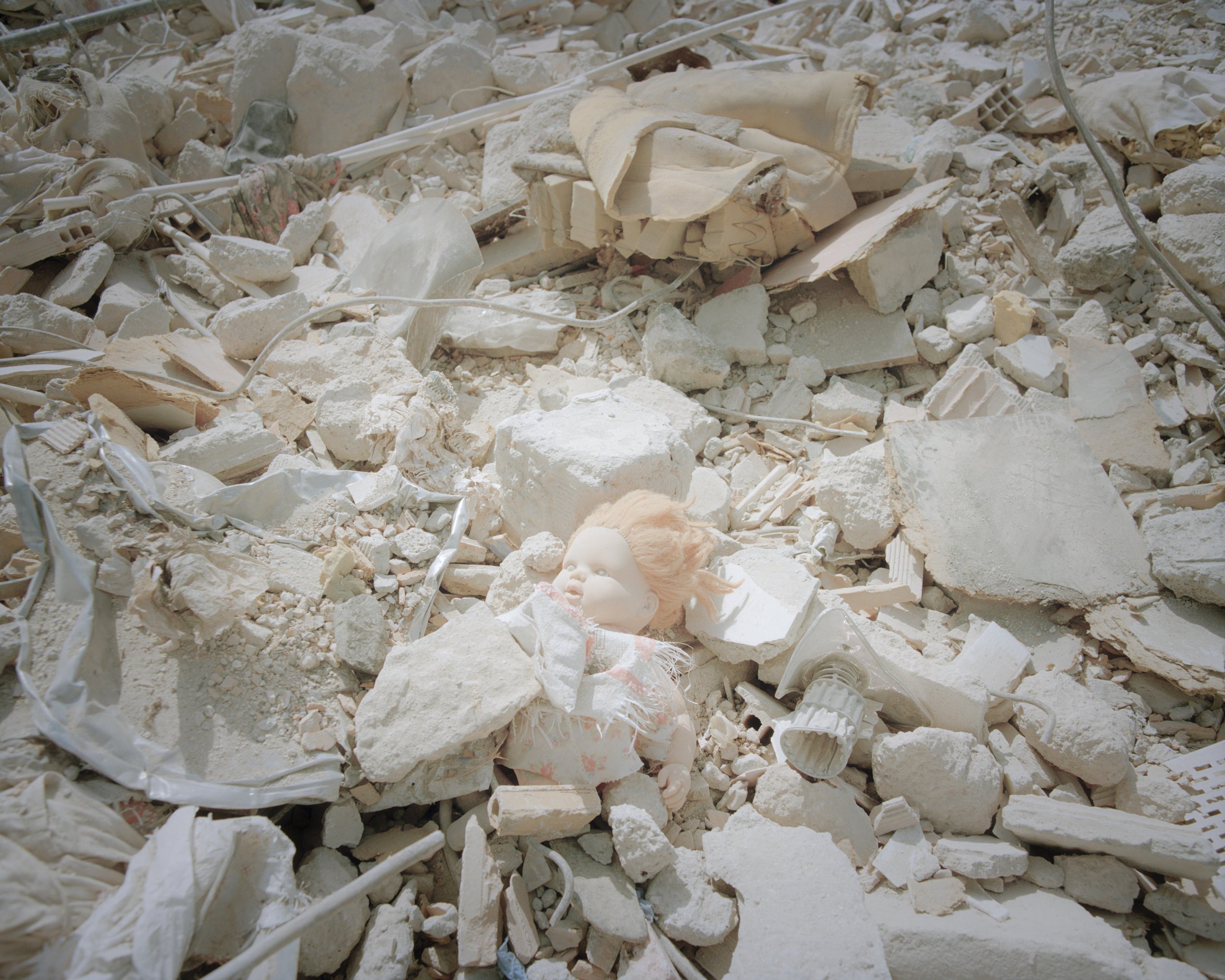 The doll is left behind in the collapsed building.