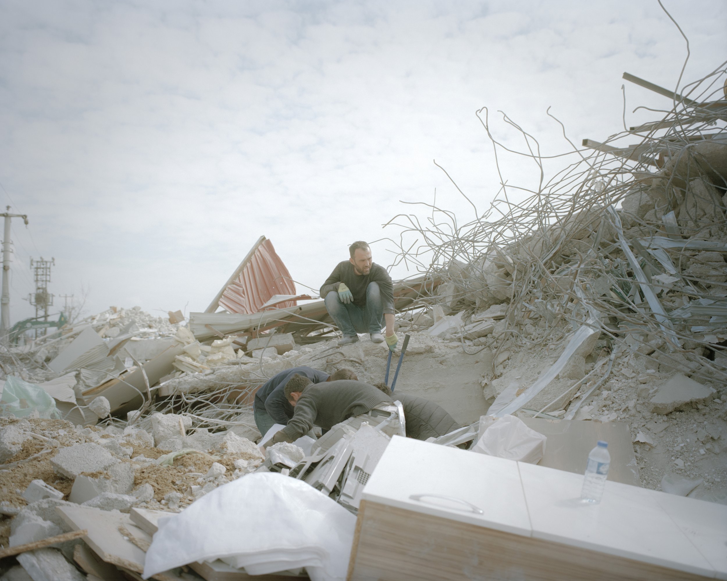 Men who search for livestock feed can use it in the rubble of the livestock feed manufacturing plant in Karamanmaras.