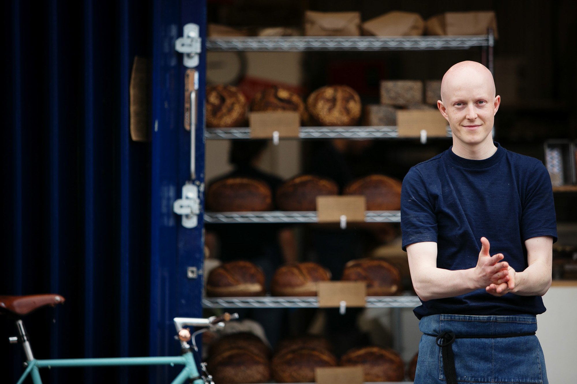 Baker in front of racks of bread.jpg
