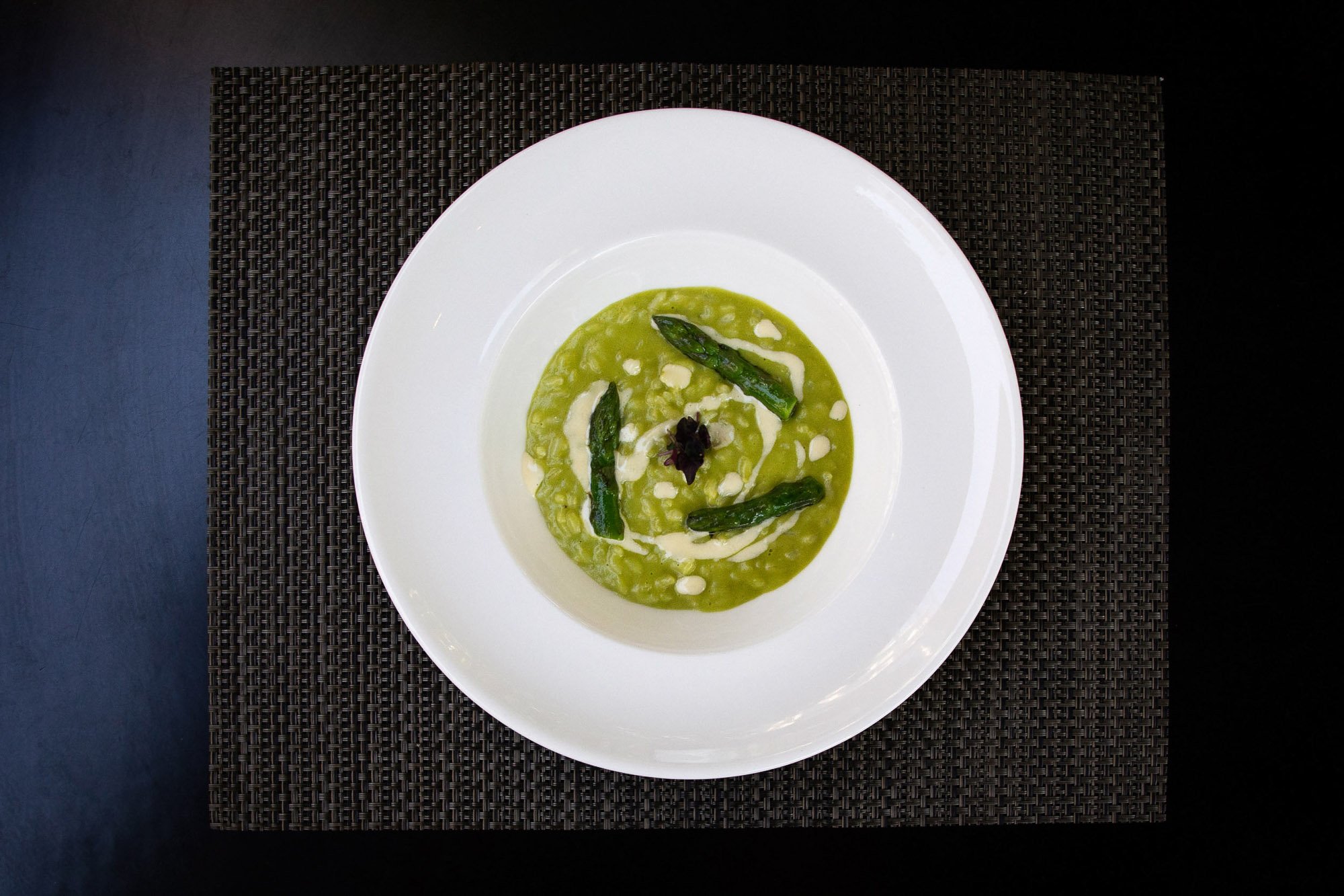 Pea risotto with asparagus served in a large white bowl.jpg