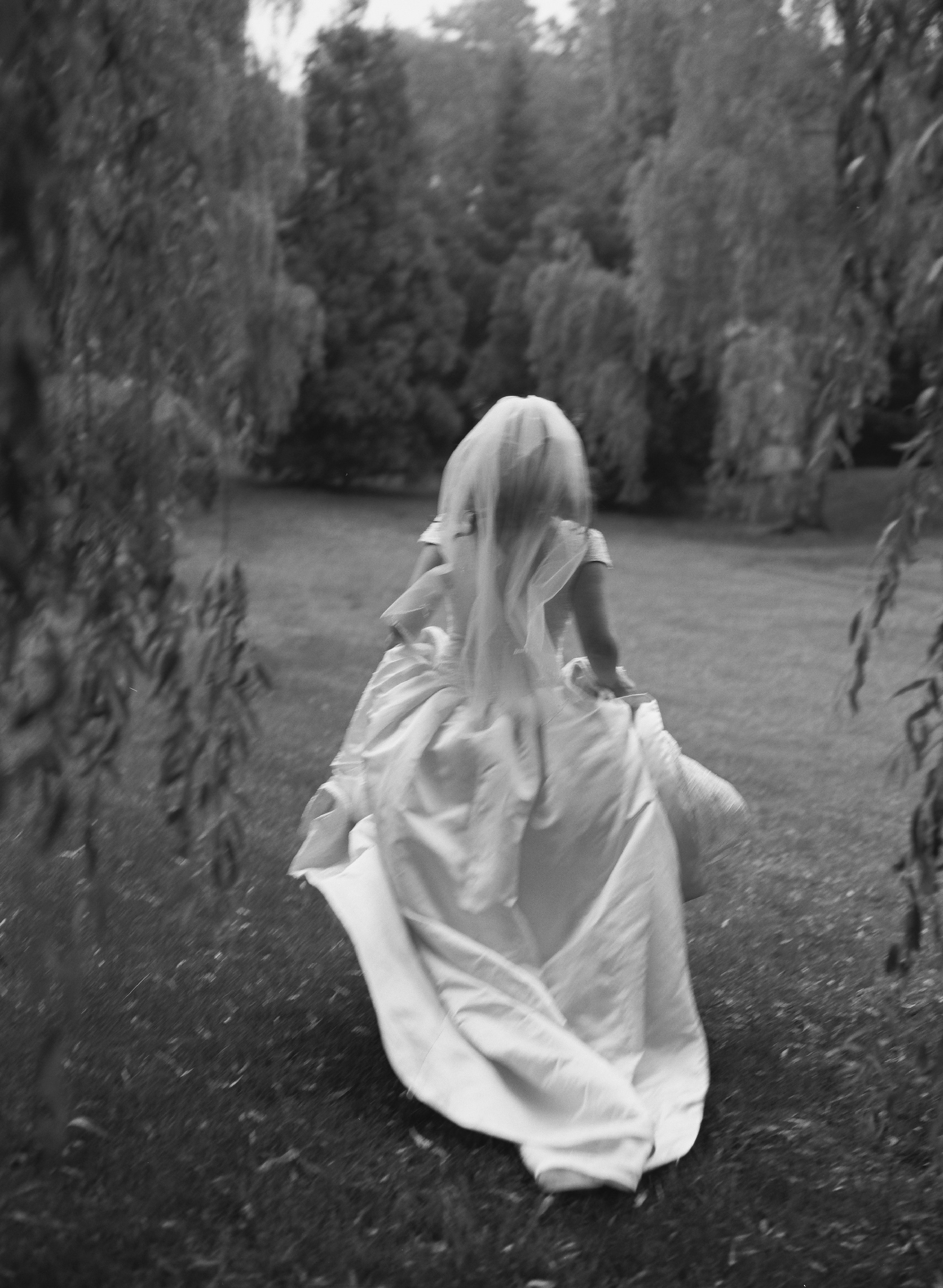 Bride running through Scottish countryside, romantic wedding captured on film