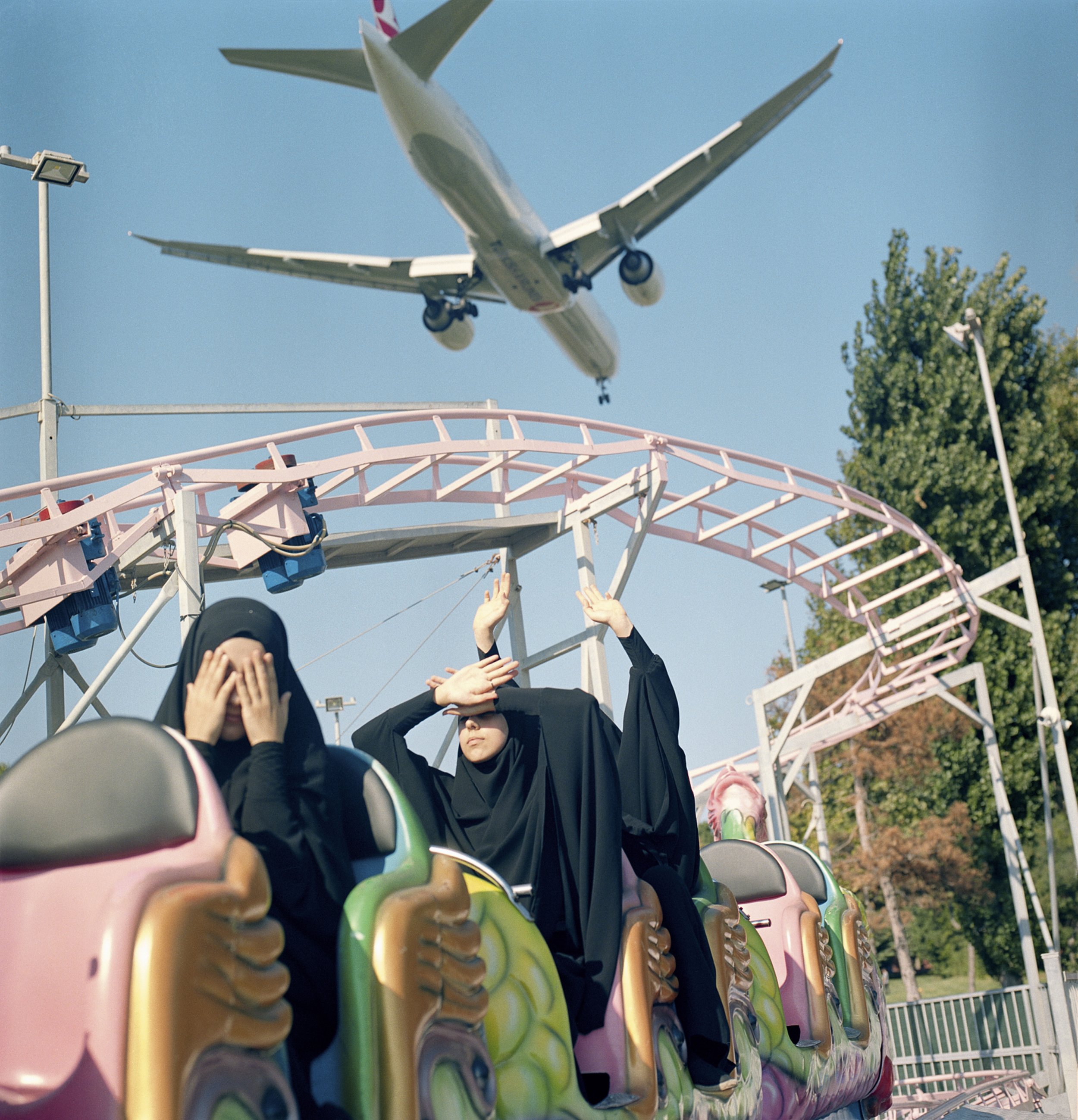 A plane flies low over students riding a train at a funfair over the weekend. Istanbul, Turkey, 29 August 2018 © Sabiha Çimen/Magnum Photos