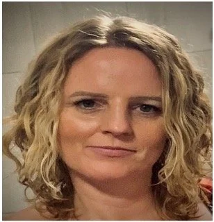 Head-and-shoulders photo of a Health Liaison Team member with short curly hair, photographed indoors against a neutral background.