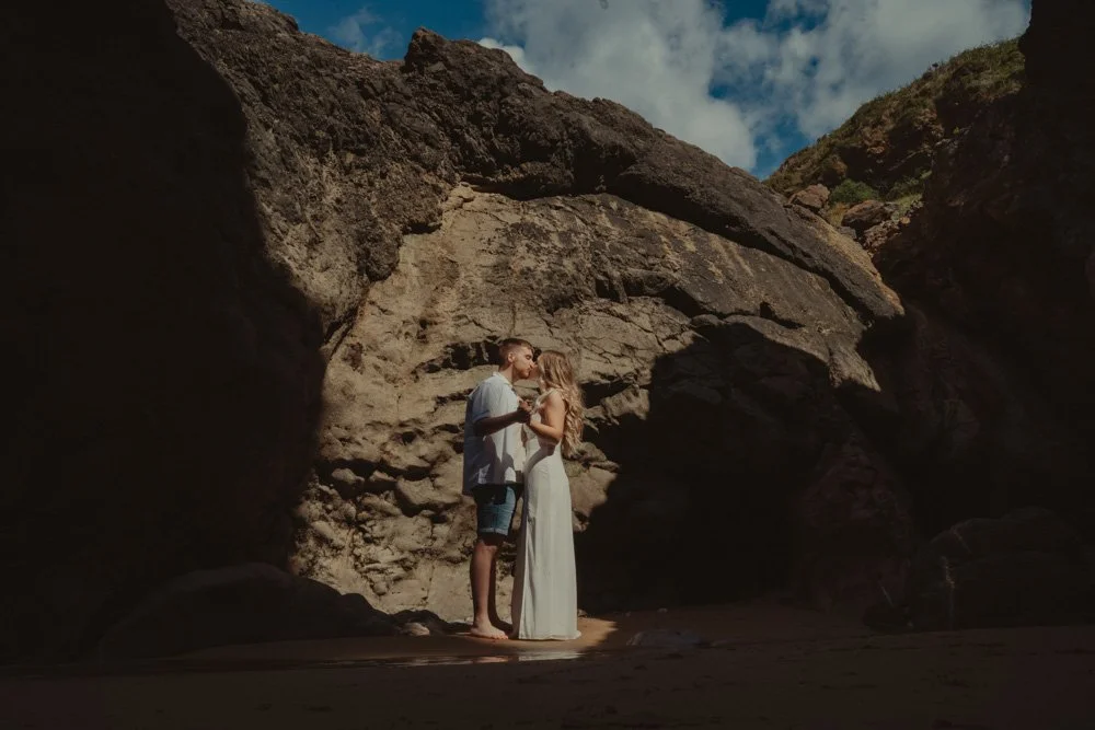 Couple dancing at their save the date photoshoot, in front of the cliffs of Three Cliffs Bay, Wales
