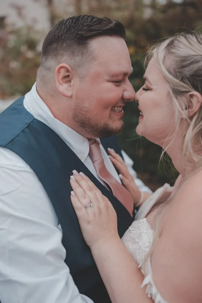 Close portrait of bride and groom laughing during their wedding