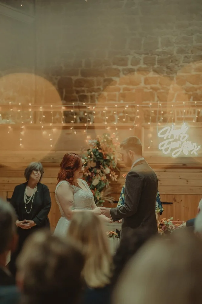Bride and groom in front of the altar at their civil ceremony, facing each other
