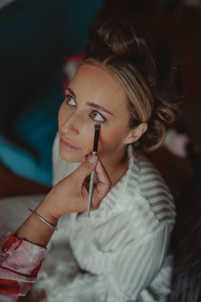 Portrait of bride getting make-up on the wedding morning