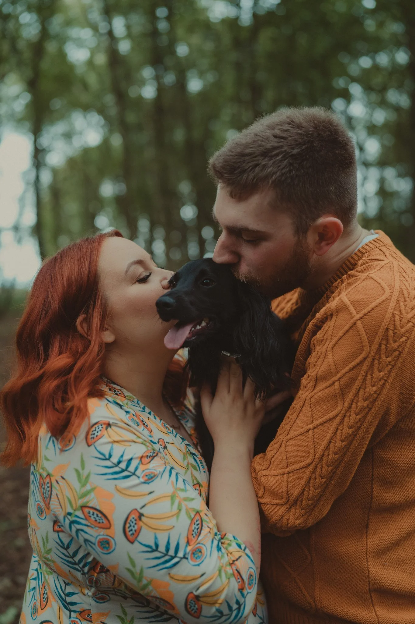 Portrait of young couple kissing their dog during a Sate the Date photo session