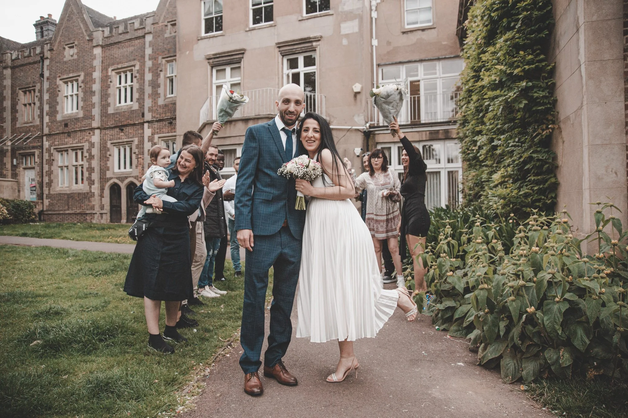 Bride and groom after their ceremony, with their guests in the back