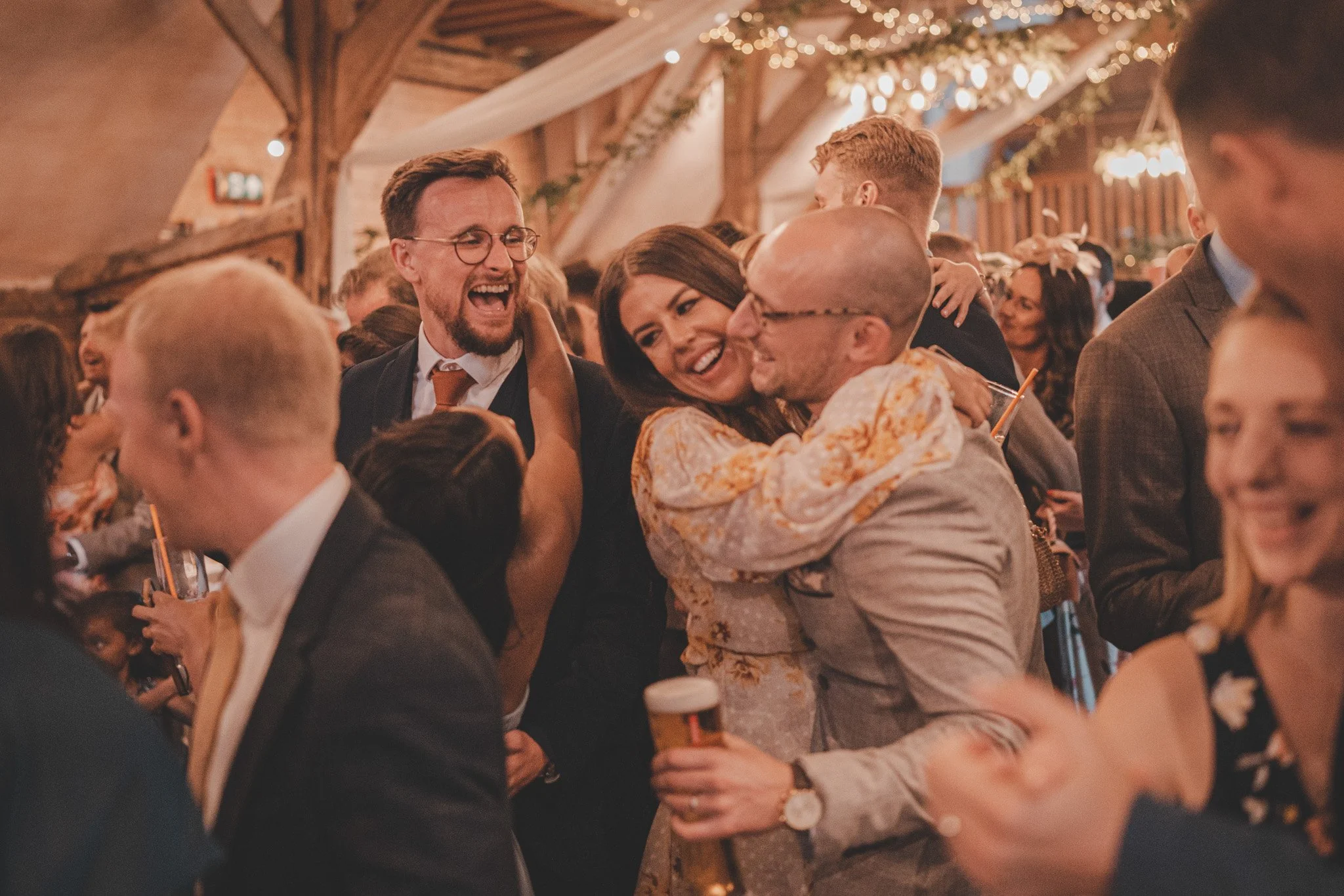Guests hugging, dancing and laughing on the dancefloor at Lains Barn, Oxfordshire