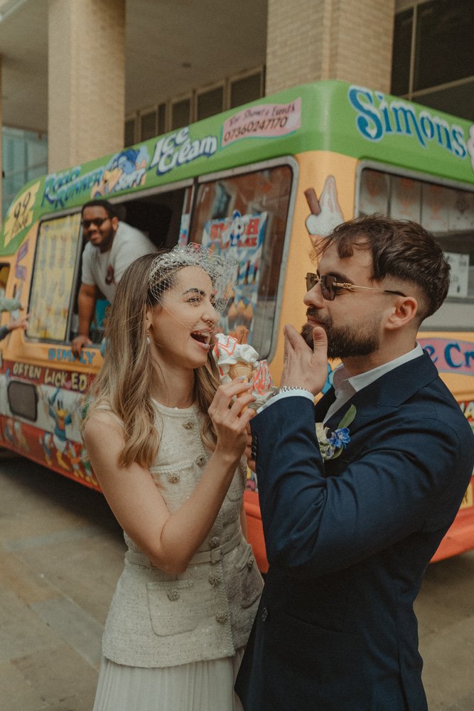 Young bride and groom eating ice cream in Birmingham city Centre on their wedding day