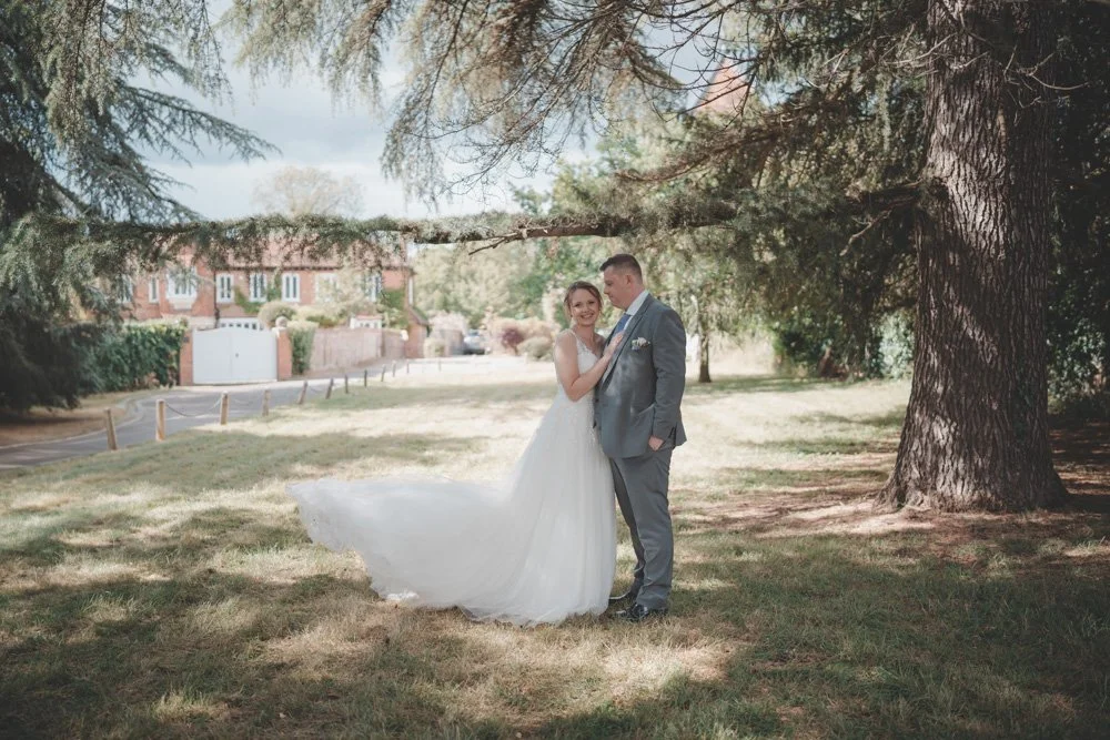 Bride and Groom photographed under the trees at Monks Barn, Hurley