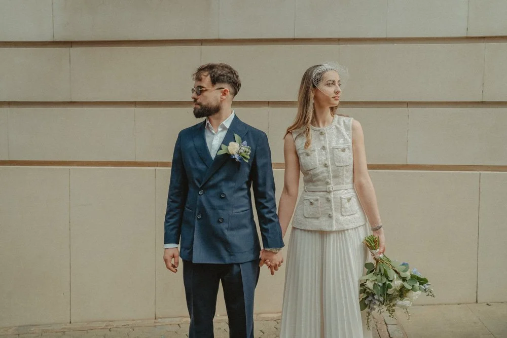 Bride and groom holding hands and looking in opposite directions in Birmingham