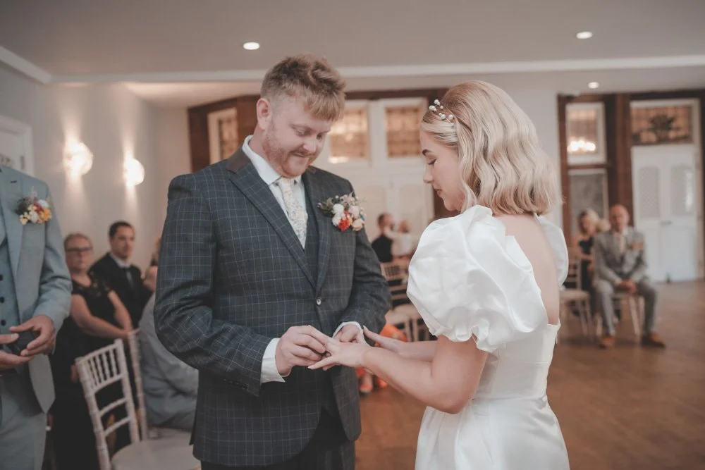 Bride and groom exchanging rings during their civil ceremony at Whitehall Hotel Darwen