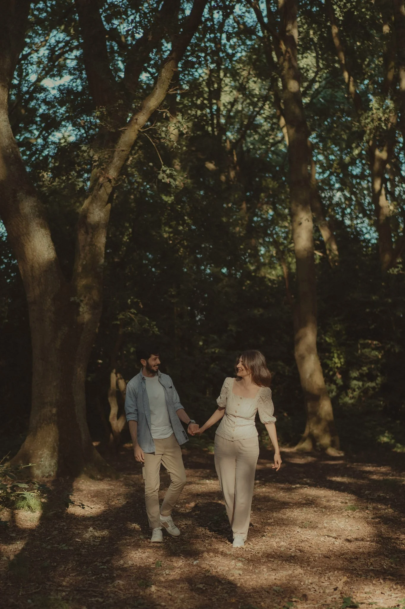 Couple walking holding hands in a forest in Coventry