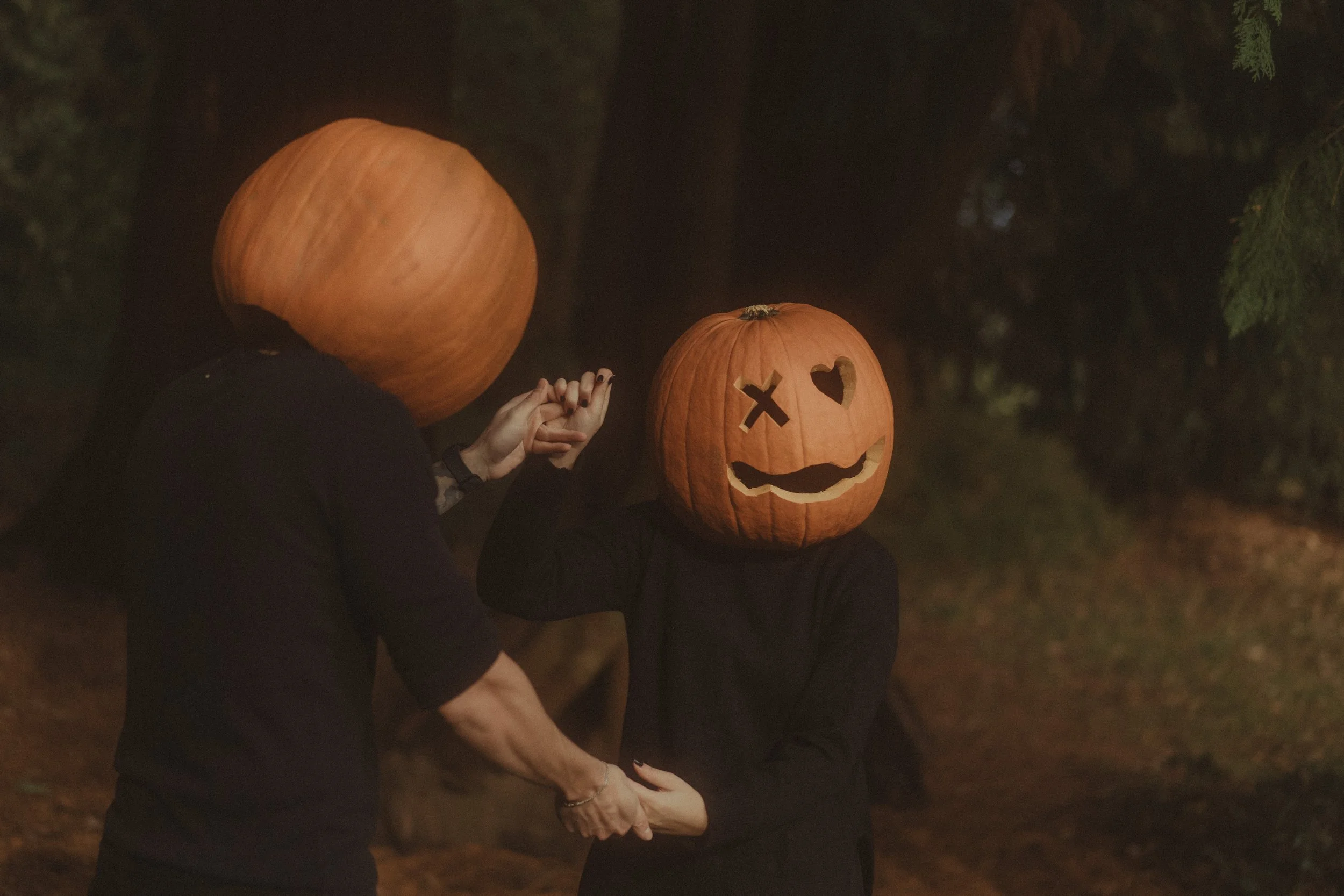 Couple wearing pumpkin heads dancing at a Halloween photoshoot in Coombe Abbey, Coventry