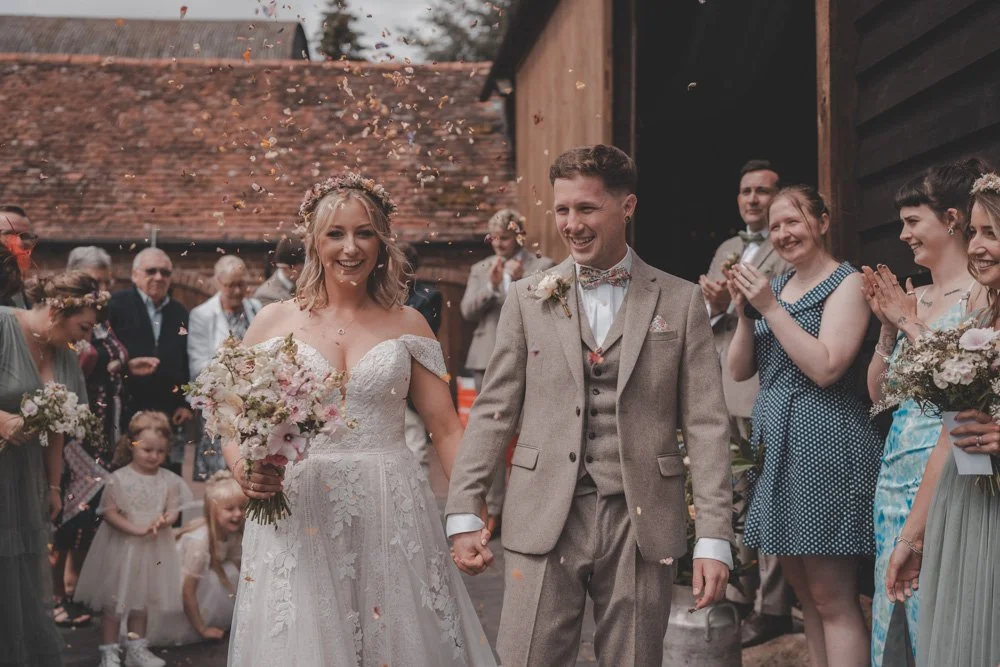 Bride and groom doing a confetti exit after a wedding ceremony, at The Courtyard at Shelsley Walsh
