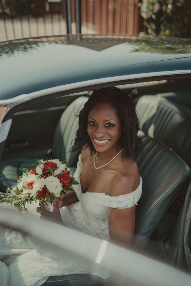Bride photographed inside a vintage car, smiling at the camera in Drayton, Oxfordshire