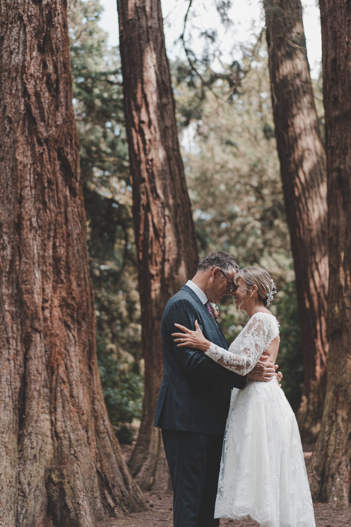 bride and groom posing together during their wedding day photoshoot in the woods of Coombe Abbey park