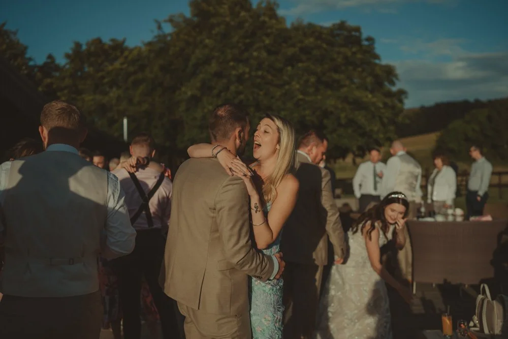 Man and woman dancing on the outside dancefloor and laughing, at Wellington Barn, Wiltshire