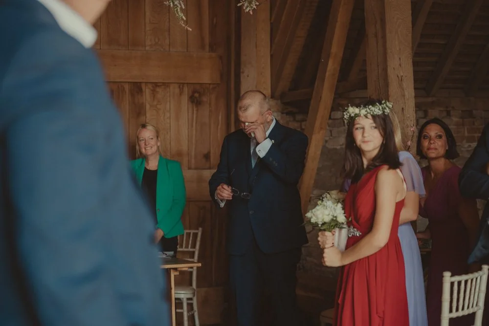 Groom crying while the bride comes down the aisle for the wedding ceremony