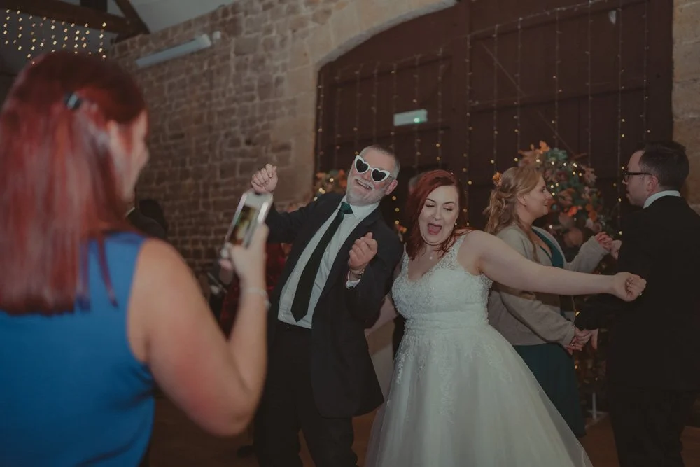 Happy bride and father photographed on the dance floor, at The Barns at Hunsbury Hill